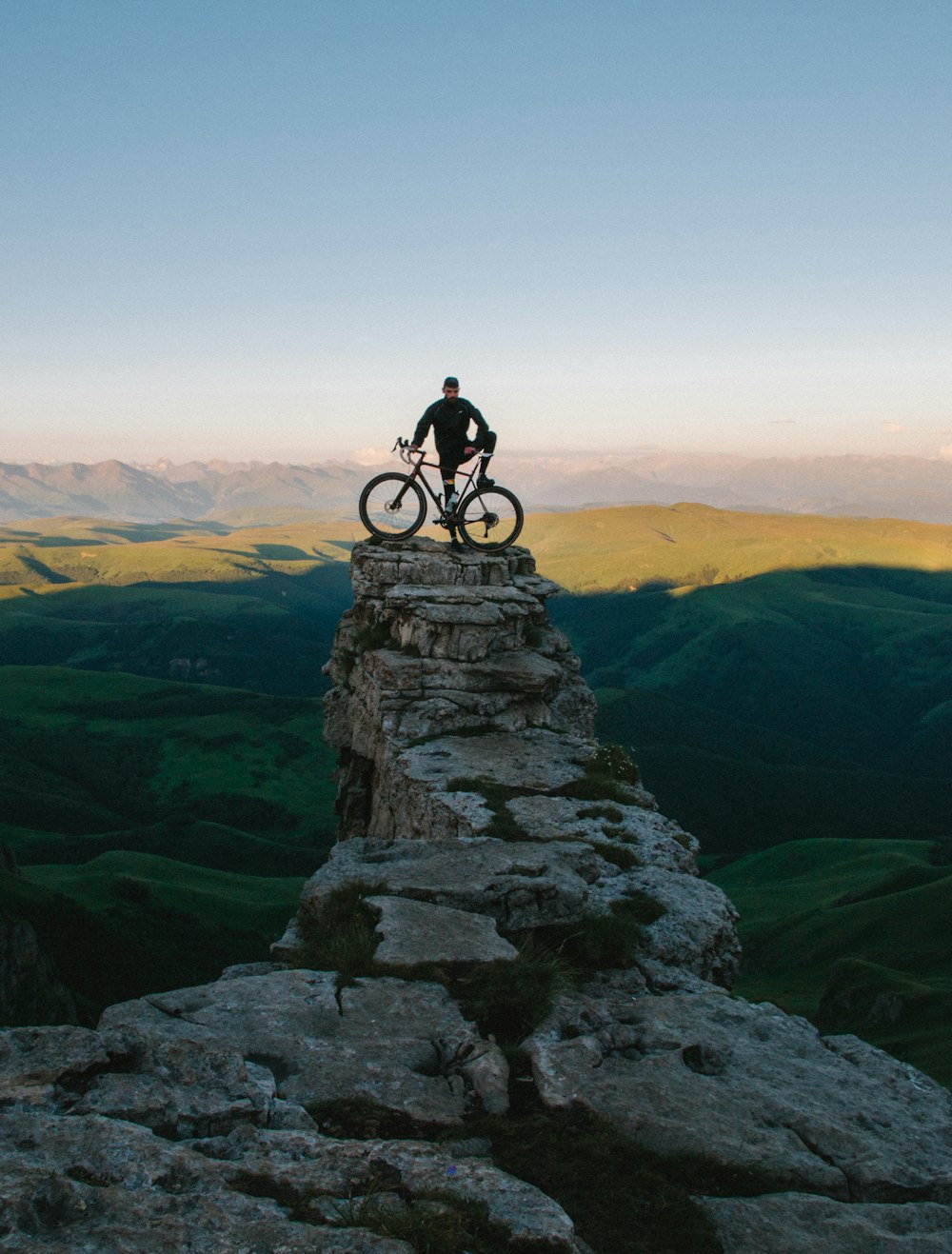A mountain biker perched on a cliff edge